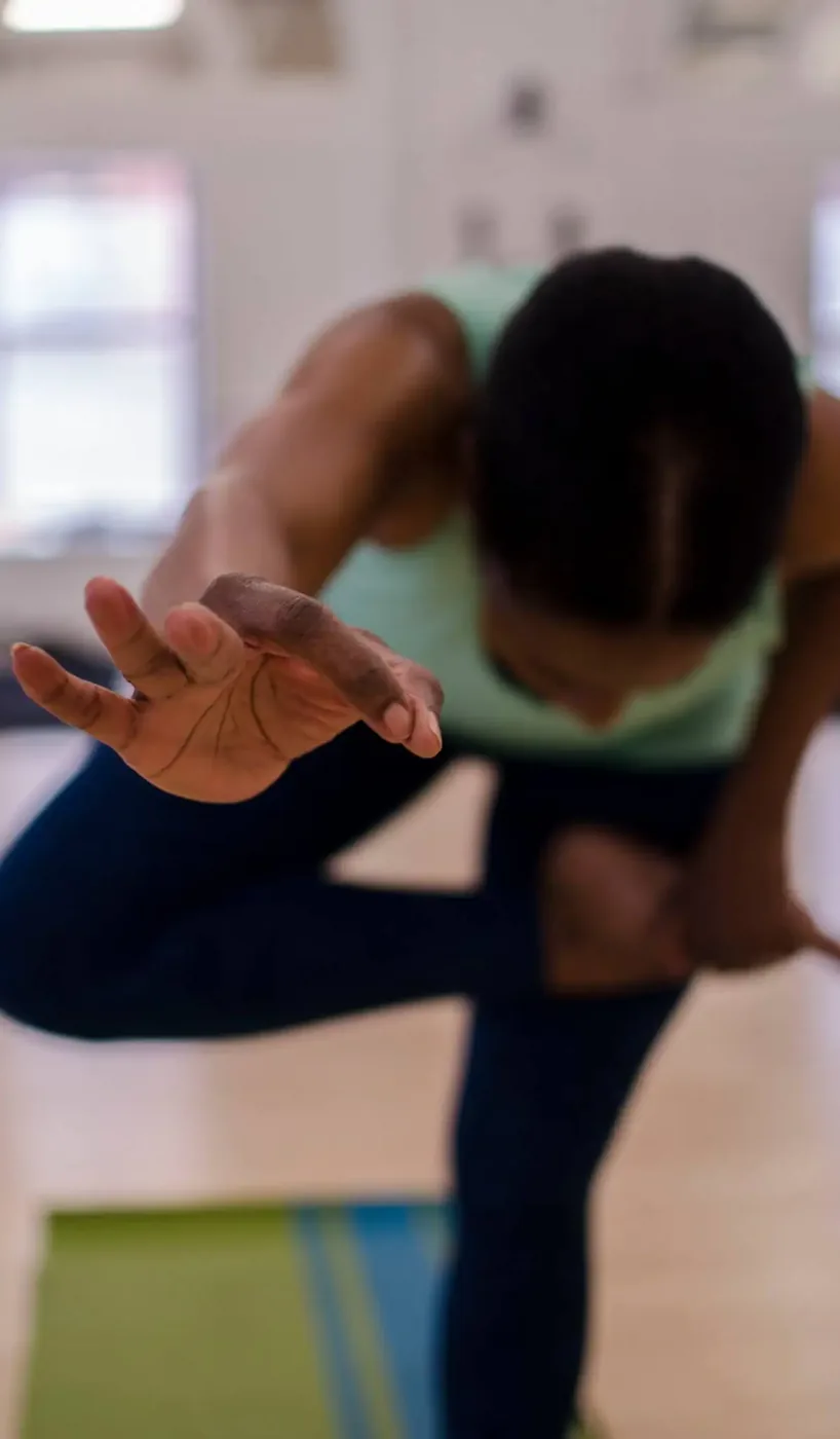 Student reaching forward in a seated twist during a yoga session